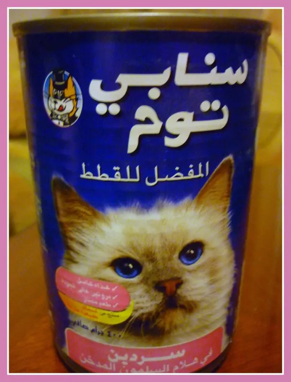 Owner reading a cat food ingredient label while comparing bags in a pet store aisle